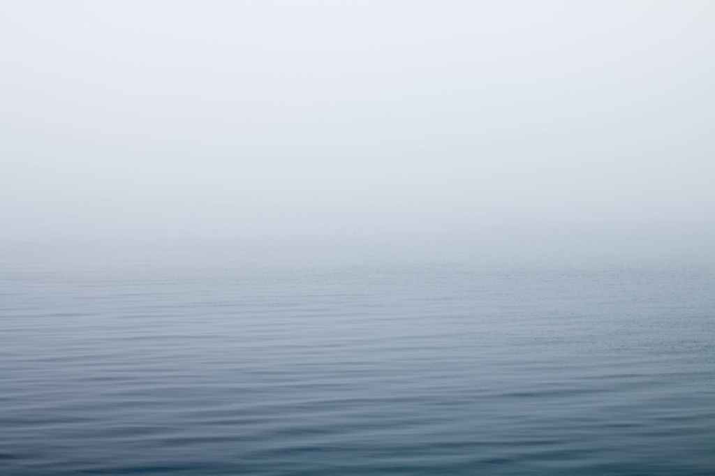 body of water under fog