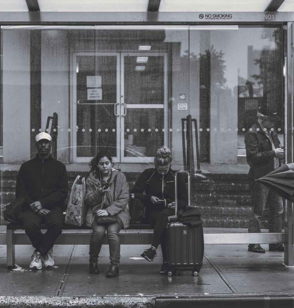 people sitting on bench at a bus stop