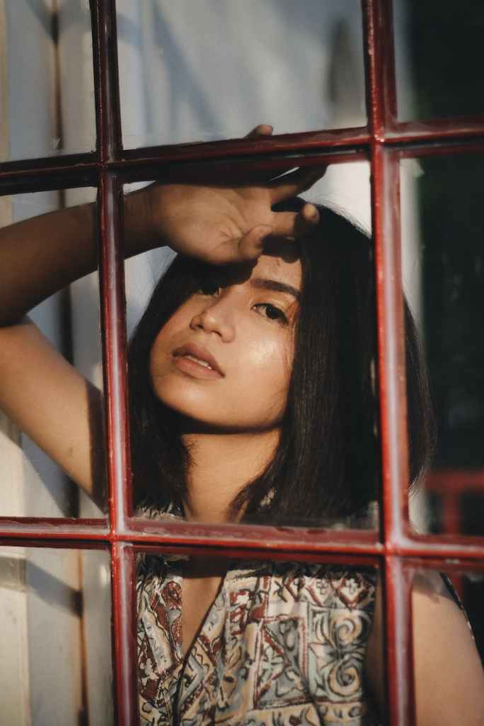 woman standing behind a barred window
